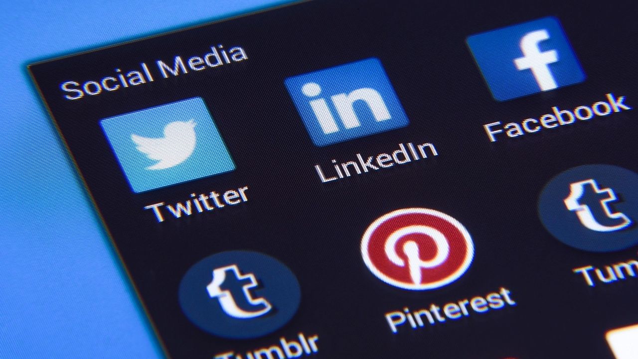 Close-up photo of a phone screen showing Twitter, LinkedIn, Facebook, Pinterest and Tumblr app icons